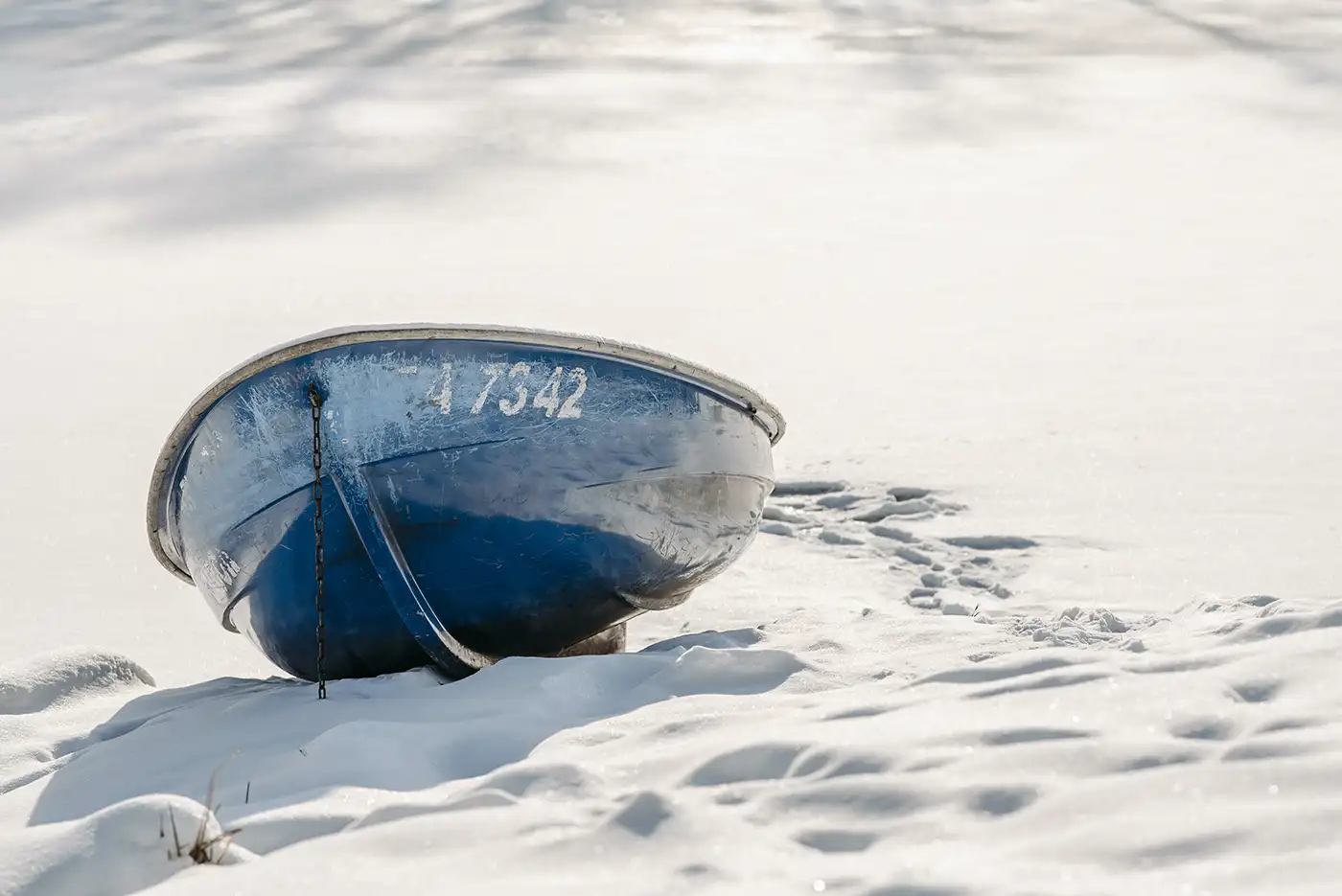 Ein am Ufer liegendes Ruderboot während des Winters.