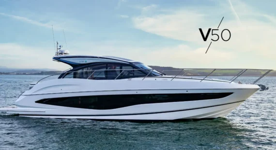 "Princess-V50" Elegant yacht Princess V50 sailing on calm waters, showcasing its sleek design against a distant shoreline.